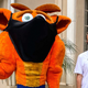 Geoff Keighley stands next to a mascot for Crash Bandicoot; both are wearing masks.